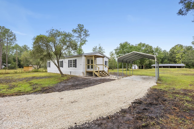 manufactured / mobile home with a front lawn and a carport