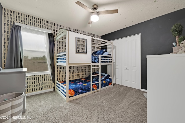 carpeted bedroom with ceiling fan and a closet