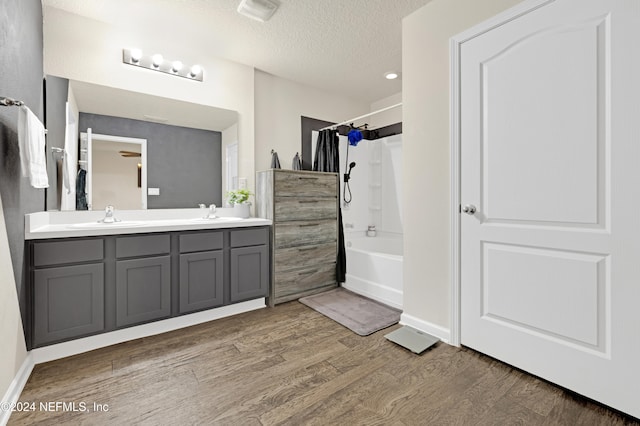 bathroom featuring vanity, hardwood / wood-style floors, a textured ceiling, and shower / tub combo with curtain