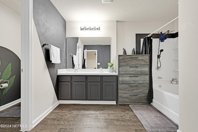 bathroom featuring vanity, wood-type flooring, a textured ceiling, and shower / washtub combination