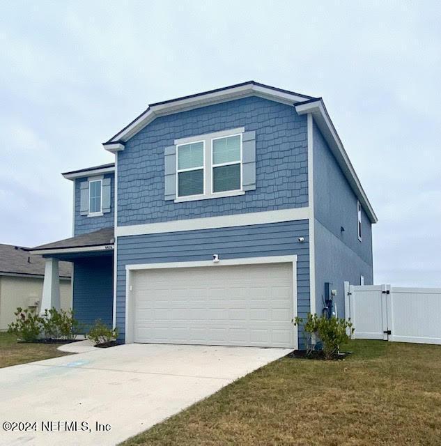 view of front of house with a garage and a front lawn