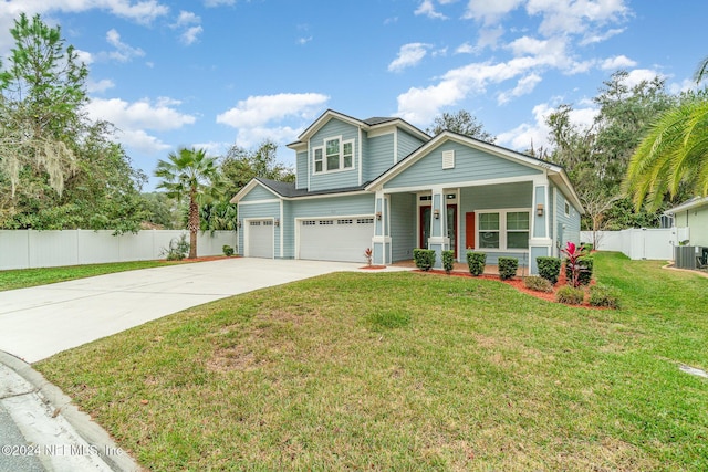 craftsman-style house featuring a front yard, a garage, and central AC unit