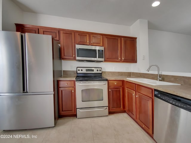 kitchen featuring sink, light tile patterned floors, and stainless steel appliances