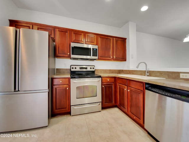 kitchen with sink, light tile patterned floors, and appliances with stainless steel finishes