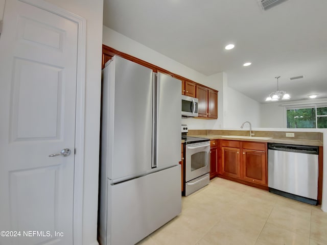 kitchen featuring stainless steel appliances, sink, light tile patterned floors, a notable chandelier, and hanging light fixtures