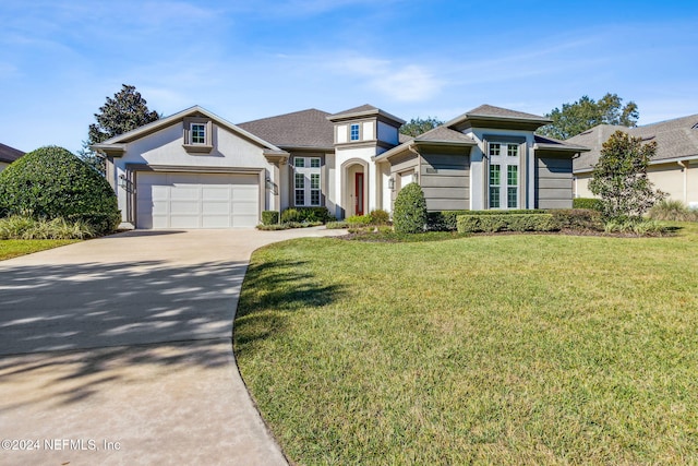 view of front of property with a front yard and a garage