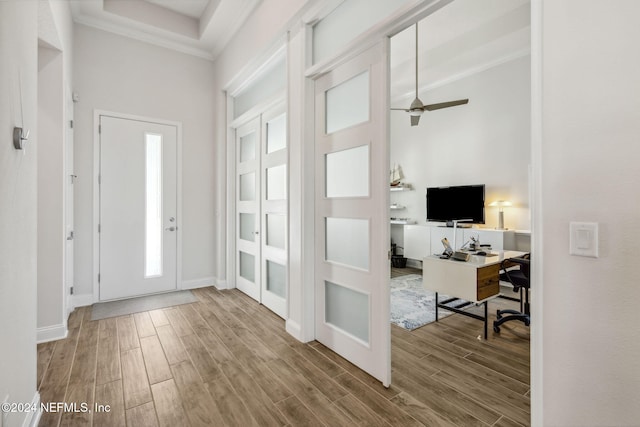 foyer entrance with ceiling fan and crown molding