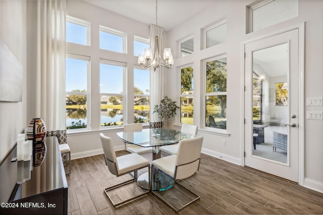 sunroom / solarium with a water view and an inviting chandelier