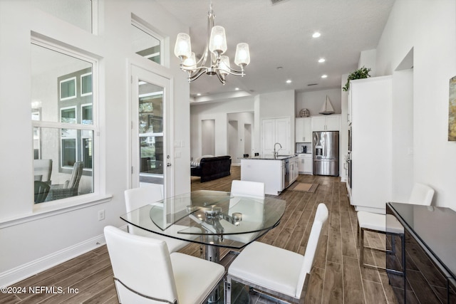 dining space featuring sink and an inviting chandelier