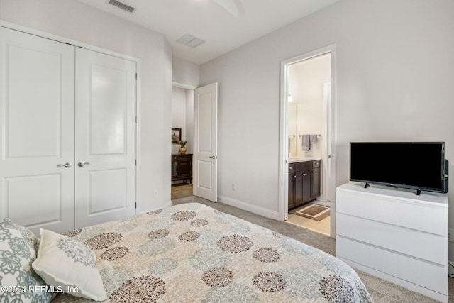 carpeted bedroom featuring ensuite bath and a closet