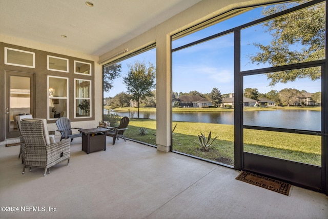 sunroom featuring a water view