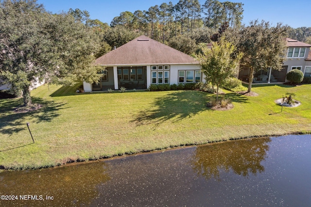 view of front facade featuring a front lawn and a water view