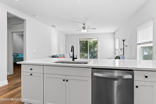 kitchen featuring stainless steel dishwasher, a textured ceiling, sink, dark hardwood / wood-style floors, and white cabinetry