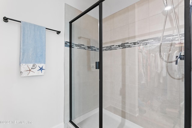 bathroom featuring a shower with shower door