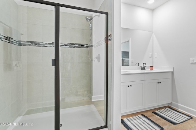 bathroom with vanity, wood-type flooring, and an enclosed shower