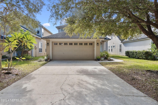 view of front of property with a garage and a front lawn