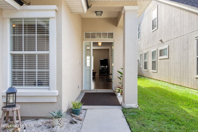 entrance to property with a lawn