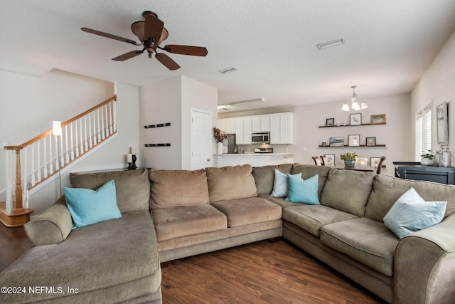 living room featuring a textured ceiling, ceiling fan with notable chandelier, and dark hardwood / wood-style floors