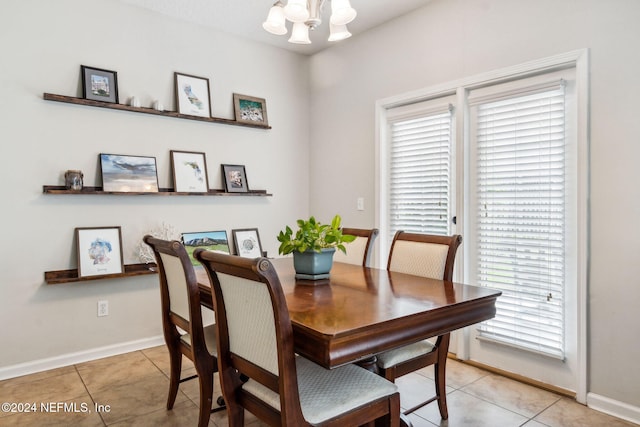 dining area featuring light tile patterned floors and an inviting chandelier