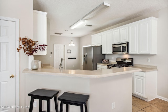 kitchen featuring white cabinetry, stainless steel appliances, kitchen peninsula, a breakfast bar, and light tile patterned floors