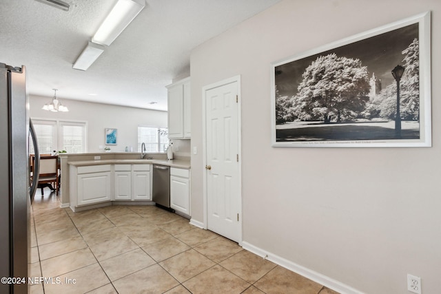 kitchen featuring light tile patterned floors, kitchen peninsula, pendant lighting, white cabinets, and appliances with stainless steel finishes