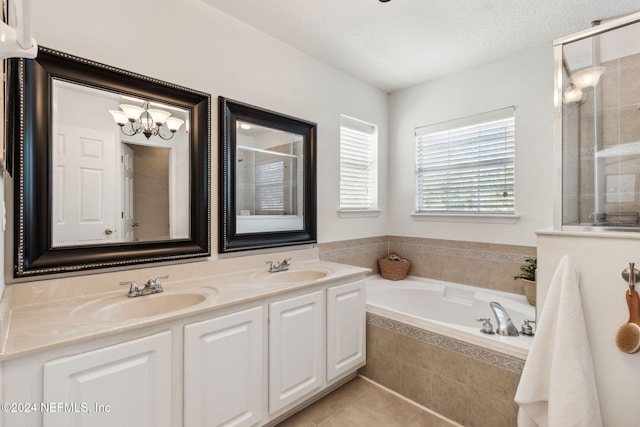 bathroom with tile patterned flooring, a chandelier, a textured ceiling, shower with separate bathtub, and vanity