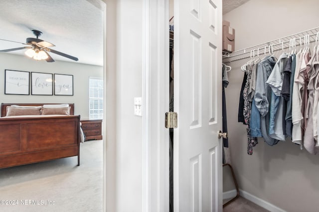 carpeted bedroom featuring ceiling fan, a closet, and a textured ceiling