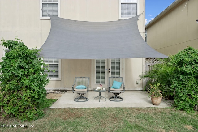 rear view of house featuring a lawn, a patio area, and french doors