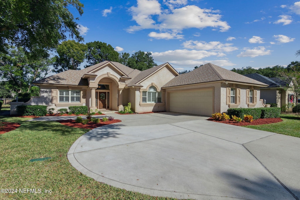 view of front of property with a front yard and a garage