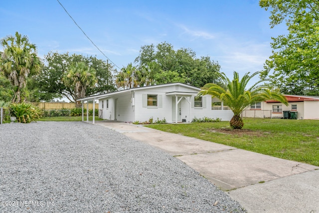 ranch-style house featuring a front yard and a carport