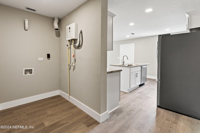 interior space featuring a textured ceiling, sink, and light hardwood / wood-style flooring