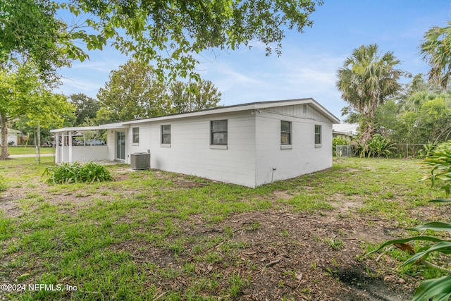 back of house featuring central AC and a lawn