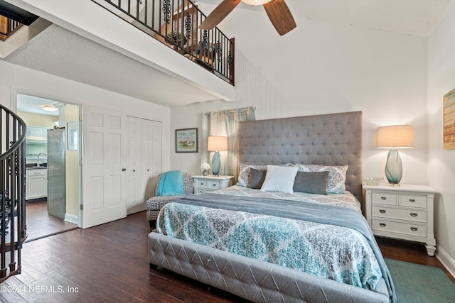 bedroom with stainless steel fridge, dark hardwood / wood-style floors, a closet, ceiling fan, and a high ceiling