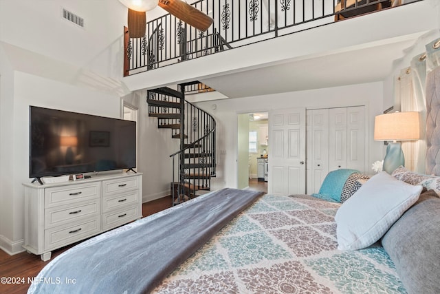 bedroom with dark hardwood / wood-style flooring and a closet