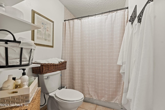 bathroom featuring tile patterned floors, toilet, curtained shower, and a textured ceiling