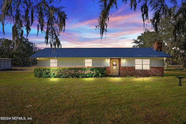 ranch-style home with a lawn