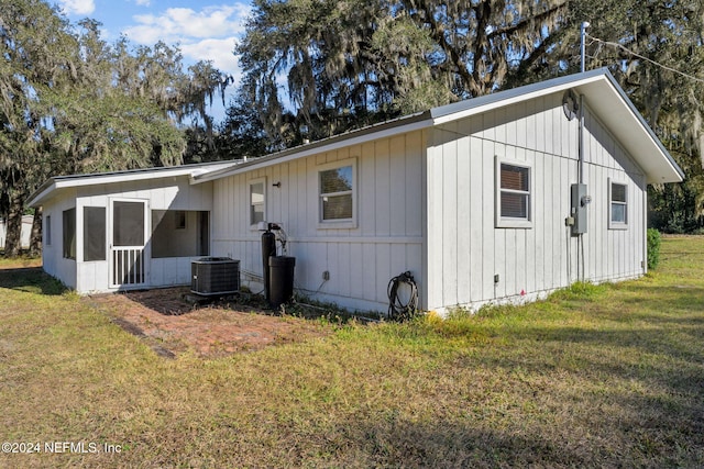 exterior space with central air condition unit and a yard