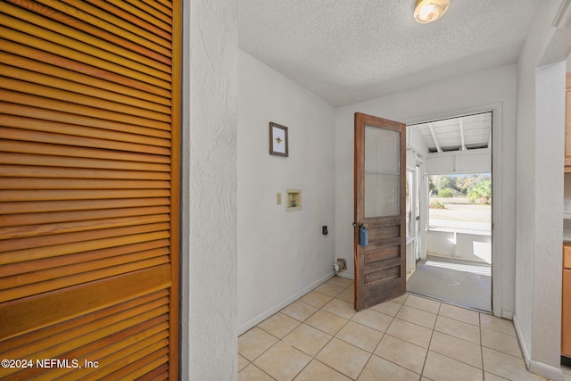 foyer with a textured ceiling and light tile patterned floors