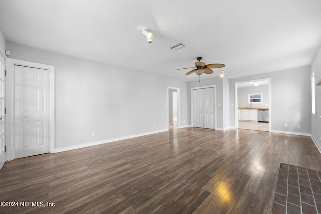 unfurnished living room with ceiling fan, dark hardwood / wood-style flooring, and sink