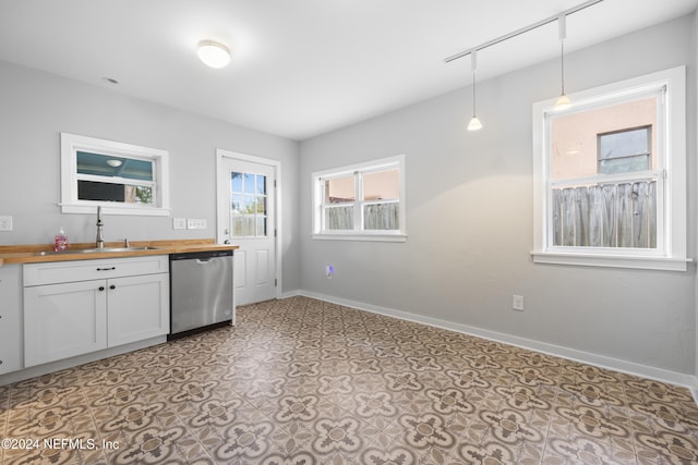 kitchen with wood counters, stainless steel dishwasher, sink, decorative light fixtures, and white cabinets