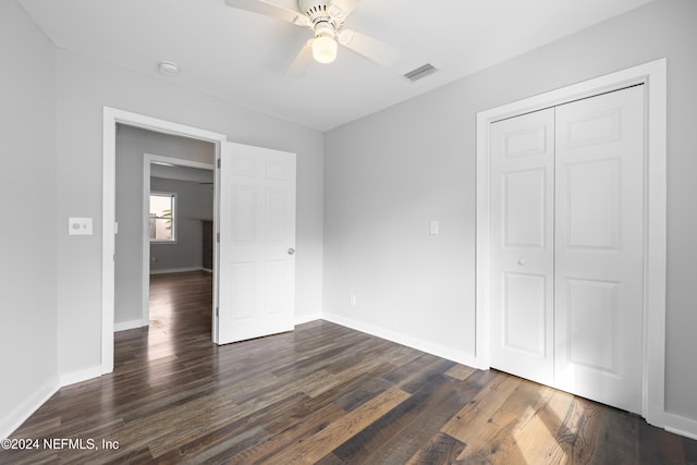 unfurnished bedroom with ceiling fan, dark hardwood / wood-style floors, and a closet