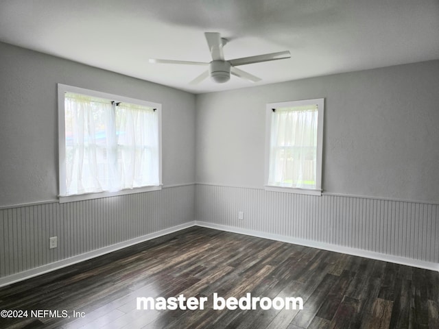 spare room featuring ceiling fan, dark hardwood / wood-style flooring, and a healthy amount of sunlight