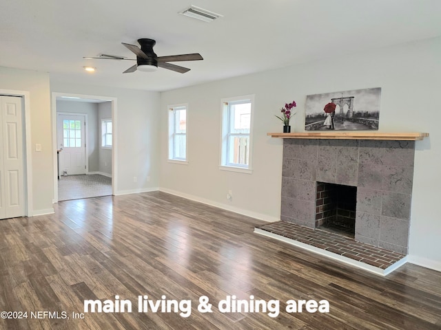 unfurnished living room with a fireplace, dark hardwood / wood-style floors, and ceiling fan