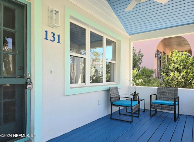 wooden deck with a porch and ceiling fan