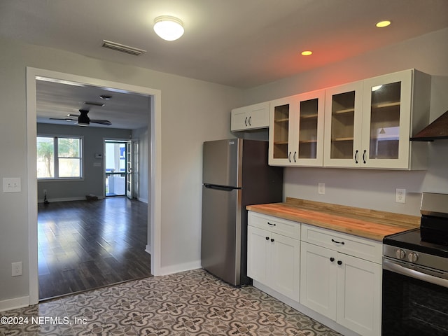 kitchen featuring white cabinetry, ceiling fan, wooden counters, ventilation hood, and appliances with stainless steel finishes