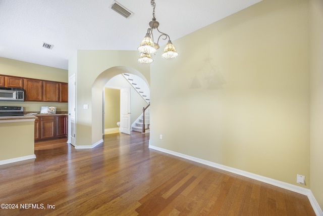 532 Dry Branch Way, Saint Johns, FL 32259 - unfurnished dining area featuring arched walkways, dark wood-type flooring, stairs, and a chandelier