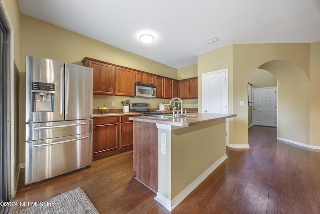 532 Dry Branch Way, Saint Johns, FL 32259 - kitchen with appliances with stainless steel finishes, dark wood-style floors, arched walkways, a kitchen island with sink, and light countertops