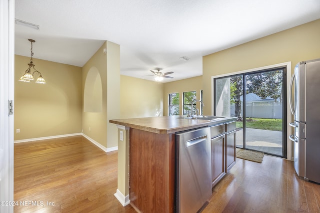 532 Dry Branch Way, Saint Johns, FL 32259 - kitchen featuring appliances with stainless steel finishes, light wood-type flooring, an island with sink, and decorative light fixtures