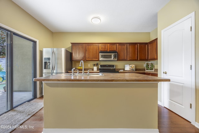 532 Dry Branch Way, Saint Johns, FL 32259 - kitchen featuring stainless steel appliances, dark wood-style flooring, an island with sink, brown cabinetry, and dark countertops