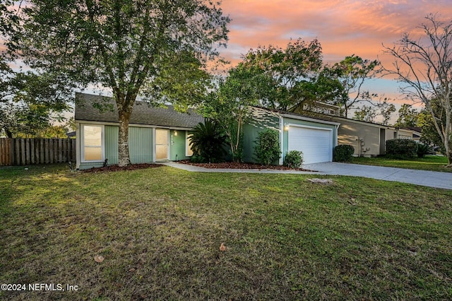 ranch-style home with a yard and a garage